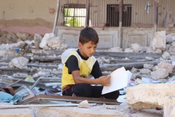 シリアで避難民シェルターとなった学校に滞在する男の子。