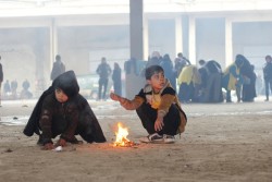 厳しい寒さから、たき火の回りに集まる男の子たち。倉庫の周りにある燃やせそうなものを全て集め、火にくべている。（2016年12月1日撮影）