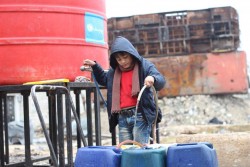 アレッポ東部にユニセフが設置した給水所に行き、水をポリタンクに入れる男の子。ユニセフは毎日トラックで給水所に水を運搬している。