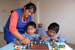 A caregiver helps two small children during a learning activity with blocks, at the Sayariy Warmi early childhood development (ECD) centre in Sucre, the capital. UNICEF supports ECD centres throughout the country. In December 2013 in Bolivia, economic growth and government investment in basic social services continue to improve the lives of children and families. The country has achieved many Millennium Development Goals (MDGs), including regarding extreme poverty, malnutrition, literacy, and gender equality; and a number of others are also on track. However, despite notable progress that includes increased safe water and sanitation access, reduced infant mortality and a decline in chronic malnutrition among children under age three, challenges remain. Income, geographical and other disparities persist, particularly in rural communities. Despite a low unemployment rate, poverty remains high with 45 per cent of the population living below the national poverty line. According to most data currently available, 11 per cent of children between the ages of 5 and 13 are involved in some form of labour, irrespective of their gender, with children sometimes working in dangerous conditions in the countrys harshest jobs  such as mining  to help support their families. Challenges in preschool and secondary education are many, although education and other social expenditures on behalf of children have increased. Current available maternal mortality rates are high, and neonatal mortality has little changed. The country also still lags behind in ensuring childrens right to an identity, especially in vulnerable communities. Working with the Government and United Nations and other partners, UNICEF supports health, hygiene, nutrition, education, safe water and sanitation, protection and emergency interventions.