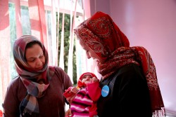 重度の急性栄養不良になって治療を受けているアブドゥルマリクくんを抱く、ユニセフ・イエメン事務所代表（イエメン・サヌア：ユニセフが支援するアル・サビン病院にて）