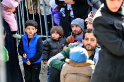 ギリシャの難民・移民一時収容施設近くで待つ家族（2016年2月撮影）