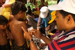 保健員から、予防接種を受ける子ども。