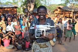Resident Rhoda Nkhambule holds a drone following a public demonstration of the technology to residents in Thipa vllage, Kasungu District, Malawi, Thursday 29 June 2017. "I know how important vaccinations are to our children," says Rhoda, "Medical staff tell us that children have to receive their vaccination on time, but our children can only receive vaccinations once a month because we are so far from the health centre. If they miss it, they have to wait for the following month, putting them at risk of catching diseases." Thipa village is 19 kilometres from the nearest health centre in Dwangwa and the only way to get there is either by bicycle or walking for four hours. On 29 June 2017, the Government of Malawi and UNICEF launch an air corridor to test potential humanitarian use of Unmanned Aerial Vehicles (UAVs), also known as drones. The corridor is the first of its kind in Africa and one of the first globally with a focus on humanitarian and development use. It is centred on Kasungu Aerodrome, in central Malawi, with a 40 kilometre radius (80 kilometre diameter) and is designed to provide a controlled platform for the private sector, universities and other partners to explore how UAVs can be used to help deliver services that benefit communities. The UAV corridor will run for at least one year, until June 2018. Since the announcement in December 2016, 12 companies, universities and NGOs from around the world have applied to use the corridor. These include drone manufacturers, operators and telecom companies such as GLOBHE (Sweden) in collaboration with HemoCue and UCANDRONE (Greece), and Precision (Malawi), all of which were present at the launch to demonstrate connectivity, transportation and imagery uses respectively. UAV technology is still in the early stages of development. UNICEF is working globally with a number of governments and private sector partners to explore how UAVs can be used in low income countries. All projects adhere to a strict set of inno
