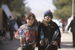 On 20 March 2018 in Adra in eastern Ghouta in the Syrian Arab Republic, children fetch water for their families from UNICEF-supported water tanks at the electricity complex in Adra, used to shelter families fleeing eastern Ghouta after four years of siege. Many children and their families are fleeing out in the open and need everything. Since 11 March 2018, more the 50,000 people have left Eastern Ghouta and thousands more are reported to be on exit points awaiting transportation to collective Shelters. In Adra, an estimated 5,400 people are currently staying in three schools-turned-shelters in the area, while over 13,000 have sought shelter in an abandoned institute, formerly used for electrical studies.  At the shelters, children and their families are living in the most basic conditions. Overcrowding and lack of existing water and sanitation systems are increasing families’ hardship. Many are forced to sleep out in the open, bearing the day’s scorching sun and the night’s dropping temperatures. Families have arrived to the shelters with very few personal belongings. UNICEF and partners were there to support in the four Adra shelters since families started arriving last week in what was the largest displacement from one location in one day, since the beginning of the Syrian conflict. Emergency water trucking is ongoing in all four shelters into water tanks installed by UNICEF. UNICEF has also installed pre-fabricated latrines at the three schools and is finalizing the installation of toilets and showers at the electricity compound. However, due to the huge influx of people on daily basis, sanitation remains a challenge. Three mobile health teams are providing primary healthcare services for children and mothers, including the provision of nutritional supplements to prevent and treat malnutrition as well as much-needed vaccinations. Most shelters do not have the capacity to accommodate the large number of people arriving. Some sites are not suitable to hos