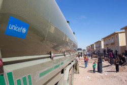 On March 17 2018 in the Syrian Arab Republic, a tanker truck brings water to the Herjeleh collective shelter in Eastern Ghouta. The shelter is among three in Rural Damascus housing thousands of people displaced from their hometowns and villages in East Ghouta by intense fighting. All of the shelters are well over capacity, and more people arriving each day. Water and sanitation facilities, non-food items such as blankets, mattresses, clothing and other essential items are all needed urgently. UNICEF and partners are providing water, sanitation and hygiene (WASH), health, nutrition, child protection and other support. UNICEF is supporting water trucking and the provision of water tanks to ensure access to safe water, and is distributing bottled water, high-energy biscuits and other water, and health and nutrition supplies. UNICEF-supported mobile health teams are also providing basic medical assistance and vaccinations for children and mothers.