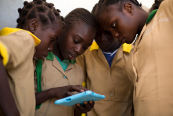 Twelve-year-old Waibai Buka (second left) teaches her friends how to use a computer tablet provided by UNICEF, at a school in Baigai, northern Cameroon, Tuesday 31 October 2017. Waibai had to flee her village after an attack by Boko Haram. She has not seen her father since the attack and fears he might be dead. UNICEF initiated a pilot project in January 2017 called ‘Connect My School’. Six solar-powered VSAT units, which enable the provision of satellite Internet access to remote locations, were deployed at schools in different parts of Cameroon. Two of the units were installed in schools in Cameroon’s Far North region: one in Minawao refugee camp, the other in Baigai, near the Nigerian border, where some 50% of children have been displaced by Boko Haram related violence.  In conjunction with the VSAT units, UNICEF has distributed child-friendly tablet computers. Through these tablets, children are able to access Wikipedia and play educational games to help them learn maths, history, geography, and so on. As of November 2017, some 2,000 children in the 5th grade have benefitted from the initiative. “I immediately started using them to search new words, play new games. I became so good at it that I now teach other children how to use this technology” says Waibai, “I was recently allowed to bring one of the tablets home with me. My mother never had a mobile phone, she didn’t know what the Internet was. I explained her and I showed her what I was doing at school with my tablet. She was so proud of me.”  “I think that we are lucky to have this technology,” adds Waibai, “my dream is to become a teacher, and with what I am learning every day on my tablet, I am sure it can become a reality.”