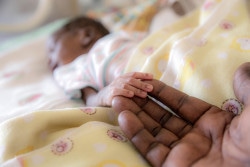 南スーダンのジュバにある病院で、わずか1300グラムで生まれ、保育器に入っている赤ちゃん。母親は分娩時の出血が原因で亡くなった。見守っている祖母が、赤ちゃんの小さな手にそっと触れている。