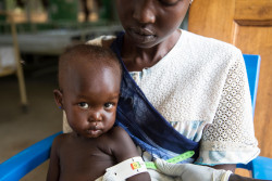 Juba, South Sudan, Daughter Afra is being checked for malnourishment. Theresa (26) with her daughter Afra (2 years and 4 months old) at the ward for malnourished children of Al Sabbah Children's hospital in Juba, South Sudan. Theresa is from Bentiu, she came to Juba in 2014 fleeing fighting. ÒI came here with my children, I have 3 kids, and my husband who is a policeman. Most of my family are up north but my sister is here looking after my other children while Afra is getting help. Afra had malaria for over six weeks. I had tried getting treatment from other clinics but she wasnÕt getting better.Ó Afra is on F75 milk treatment two hourly. Little Afra is still nervous around the doctors as she is weighed and measured. But the doctors on duty say that in one day she is already looking better. ÒI am not well because my baby isnÕt getting better. The other children are ok. I also canÕt work in my business while I am here, I sell tea in the market to make money for my family. I hope for a good life in the future, there doesnÕt seem to be any way.Ó - Theresa Conflict and underdevelopment have plagued South Sudan for decades, leaving its children out of school, malnourished and vulnerable to disease, abuse and exploitation. The prospect of a better future following the countryÕs independence in 2011 was short-lived following the eruption of a civil war in 2013. Malnutrition rates are at critical levels. More than 1 million children are malnourished, including 300,000 severely so and at risk of death. The proportion of people who do not know where their next meal is coming from went up from 35 per cent in 2014 to nearly 60 per cent at present, with some areas of the country one step away from famine especially during the lean season. The conflict has also pushed hundreds of thousands of children out of school, with 1 in 3 schools damaged, destroyed, occupied or closed since 2013. South Sudan now has the highest proportion of out-of-school children in t