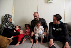 タレックさんの両親から、シリアからギリシャに逃れて来た時の様子を聞く長谷部選手。