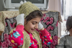 冬用の帽子や服を受け取った子ども（2018年2月撮影）。ユニセフは毎年、難民や国内避難民の子どもたちに冬用衣料などを支援している。