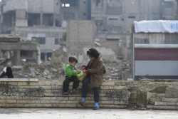 On 10 December 2018 in the Syrian Arab Republic, children sit on a fence near the central mosque in Douma, East Ghouta. Douma is home to the largest population in East Ghouta with more than 250,000 people living amidst large scale urban destruction, wide contamination with explosive remnants of war and limited access to essential services. UNICEF Executive Director Henrietta H. Fore is visiting the Syrian Arab Republic from 8-13 December 2018. In Douma, East Ghouta, just a few months after a seven-year siege was lifted, displaced families are beginning to return and the town’s population is now estimated at 200,000. Many families have moved back into damaged buildings, and the threat of unexploded ordnance is pervasive. Since East Ghouta became more accessible UNICEF, through its partners, is providing a more comprehensive package of services including education, water and sanitation, health and nutrition and child protection. Since May 2018, 23 children have been killed or injured in all of East Ghouta as a result of explosive remnants of war. There are 20 schools in Douma, all of them need varying degrees of rehabilitation. Such is the level of destruction in the town that a non-governmental partner organization set up an informal clinic, with UNICEF support, in the hall of a damaged mosque. The clinic, one of only six health facilities in the town, and offers vaccination and nutrition services as well as treatment for common childhood diseases. In Hama, which saw violent fighting between rebels, government forces and extremists before falling back under government control, the UNICEF Executive Director visited a center where young boys and girls learn how to stand up against gender-based violence. On the last day of the trip, Fore visited Deraa, the birthplace of the Syrian uprising, and home to nearly 1 million people. Deraa has seen very high levels of displacement, with people moving frequently and for short periods of time, and putting additional strai