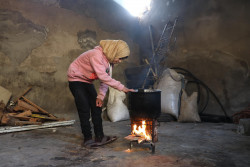 アレッポ東部の自宅で、料理をするために火をつける12歳のガーダさん。冬服が足りず、体調を崩すことも多い。(2019年1月22日撮影)