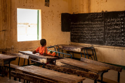Children at a UNICEF supported community school in Agadez, Niger, on May 11 2018. School attendance in Niger is extremely low, and seen as an ongoing challenge. In May 2018, between the sun and the dusty wind, the temperatures in Agadez, Niger are about 45 degrees celsius. The region is known for uranium and salt mines, though it has become infamous as the last way station for migrants and refugees who are being smuggled to Europe, or Algeria and Libya where they are likely to work as beggars. Recently, Algerian and Libyan authorities have been rounding up migrants and forcibly sending them home. Since the E.U. largely stopped mass migration into Europe, people wait for months in some cases for a chance to move on, or to be moved back home.