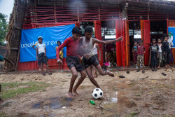 バングラデシュ・ロヒンギャ難民キャンプ内のユニセフが支援する子どもにやさしい空間で、サッカーボールを追いかけ遊ぶ子どもたち。