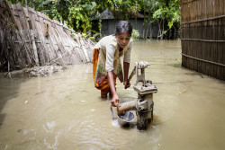 During the 2016 floods in Kurigram, northern Bangladesh, a girl tries to pump clean water from a standpipe. The contamination of drinking water supplies is a major risk during flooding.