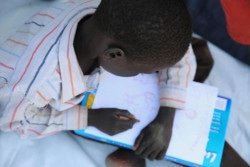 A child draws a picture in a Child-Friendly Space for children who’ve been separated from their families. By identifying these children, UNICEF Child Prottection Specialists can begin the process of Family Tracing and Reunification (FTR). UNICEF Rapid Response Mission (RRM) to New Fangkak, Jonglei State, South Sudan. Sunday 22 July 2018.