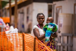 Masika Mbweki, 31, holds her son, Japhet, 10 months, by their room in the quarantine area of the Ebola Teatment Centre of Butembo, Democratic Republic of Congo, 22 March 2019. After her son fell very sick, Masika brought him to health centre, where medical workers then transferred him to the Ebola wing. A few days later she started feeling sick and showed the first symptoms of Ebola. Both now wait for the blood results to see if they are positive. Since the beginning of the epidemic, UNICEF and its partners have deployed more than 650 staff to work with Government, civil society, churches, and NGOs to raise awareness about available care, as well as the best hygiene and behavioural practices to prevent Ebola from spreading.