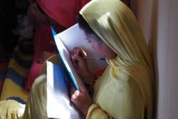 自分の夢をテーマに、作文を書く女の子