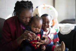 生後7カ月の妹と4歳の弟の面倒を見る南アフリカの少年。(2019年5月撮影) 