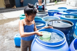 容器に水を汲む9歳のダグリアニス・ゴンサレス・サンチェスちゃん。(2019年7月25日撮影) 