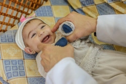 パレスチナ・ガザ地区に設置されたユニセフのECDセンターで、保健員に笑顔を見せる生後10カ月の赤ちゃん。(2019年1月撮影) 
