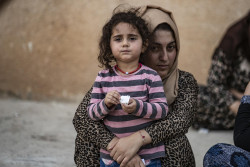 On 11 October 2019 in the Syrian Arab Republic, a woman holds a child as families displaced from Ras Al-ain arrive in Tal Tamer, 75km southeast Ras of Al-ain, having fled escalating violence. In early October 2019, as violence escalates in northeast Syria, many children are at imminent risk of injury, death and displacement. of Ras al-Ain and Tal Abiad. Since the start of the hostilities on 9 October 2019, an estimated 130,000 people have fled from areas around Tal Abiad and Ras Al-ain. Most of the 18,000 people living in Tal Abiad town and 11,000 people living in Ras Al-ain have reportedly fled towards Tal Tamer and Hasakeh City. While most of the displaced are being hosted in the local communities with relatives, some have sought refuge in collective shelters in schools and unfinished buildings. An estimated 33 collective shelters have been identified. In Tal Tamer, 18 schools are hosting an increasing number of IDPs. While significant further displacements continue, UNICEF’s partners have started providing emergency assistance to families arriving at collective shelters in Hassakeh city and Tal Tamar.