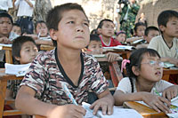 写真：甘粛省清水郡の村の子どもたちは、木陰で勉強しています。