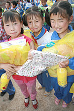 写真：ユニセフが支援した学校用品や制服を手にする子どもたち。