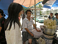 写真：屋台で焼とうもろこしを売る男性