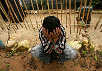 ガザのベイト・ハヌーンで行われた二人の友達のお葬式で、両手で頭を抱えて泣く男の子。