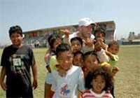 ユニセフペルー親善大使のジャン・マルコ・ジニャーゴ氏が視察先で子ども達を励ます。