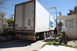 シリアに向け、小さな金属ゲートを通って進むユニセフの物資輸送トラック。