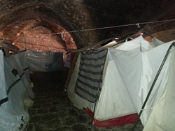 地下室にテントを張って生活する避難民