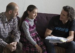 アンマンで、女の子が描いた絵を見ながら会話をするブルーム大使