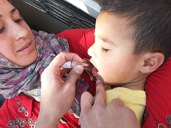 ポリオワクチンの投与を受ける子どもと見守る母親