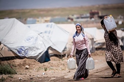 水を運ぶシリア難民の女性