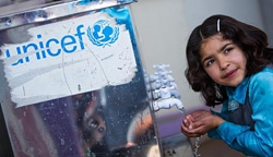 イラク北部のドミーズ難民キャンプにある学校で水を飲む少女。