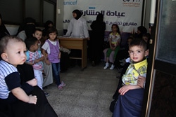 アレッポ市内にあるユニセフが支援する診療所で診察を待つ子どもと母親