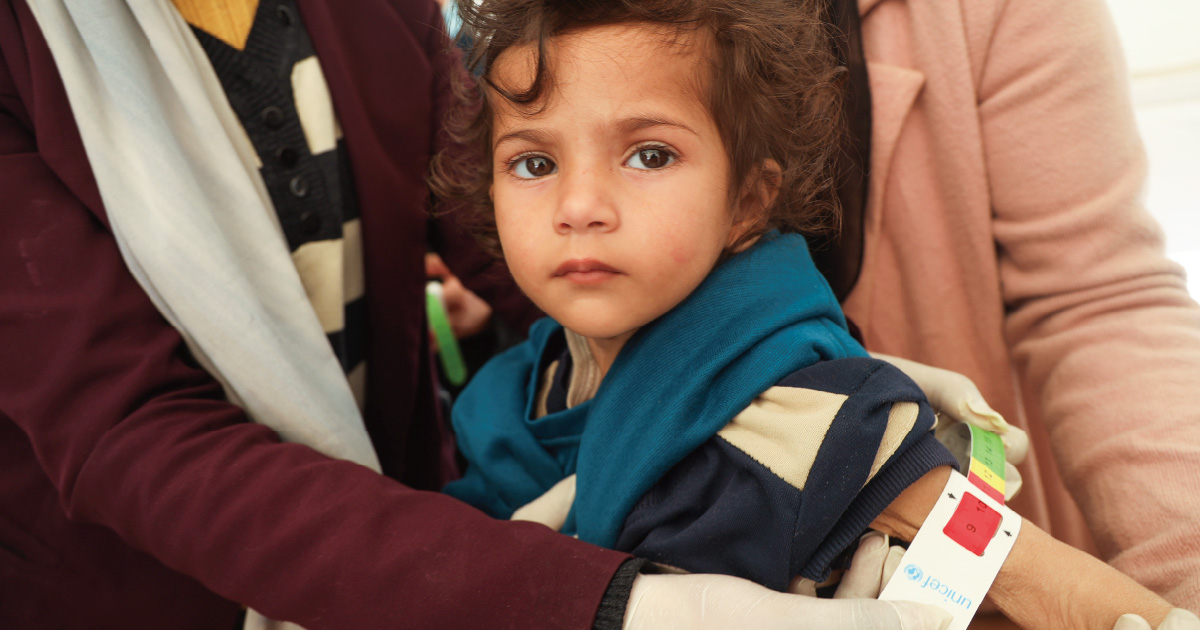 上腕計測メジャーで、栄養不良を意味する「赤」が示された2歳の女の子（ガザ地区）