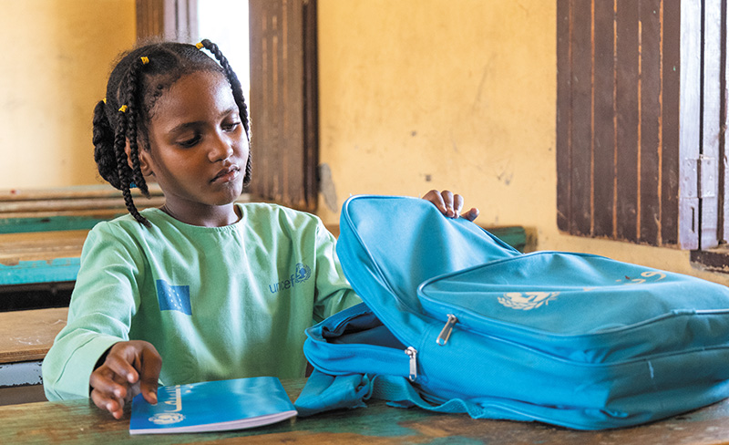学用品がたくさん入る新しいバッグに希望を感じるウィサムさん（スーダン）