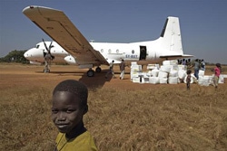 ワクチンを飛行機から下すスタッフと男の子（南スーダン）
