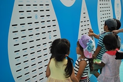 『みんなの募金箱』の1000の名前から、一生懸命自分の名前を探す子どもたち