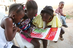 ユニセフはエボラの感染拡大を阻止するため、啓発活動に力を入れている。予防法のポスターを読む子どもたち。（リベリア）