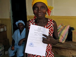 エボラ出血熱から回復し、退院証明書を見せる女性。