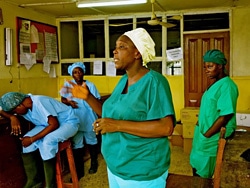 シエラレオネ東部州のケネマ地区病院のエボラ・ユニットで、同僚と会話をするシスター・ナンシー。