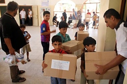 ユニセフは衛生用品や貯水用容器、毛布を配布。避難所になっている学校で支援物資を受け取る子ども。（ガザ）