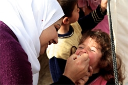 ポリオの予防接種を受ける女の子。（イラク）