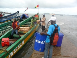 支援物資を持って離れた島へエボラの啓発活動に向かうユニセフ・スタッフ。（ギニア）