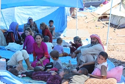 ナウルズ難民キャンプで、テントの下で日差しをよけながら休むヤズディ教徒の人たち。